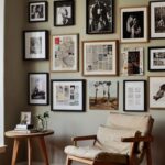 A vibrant and eclectic gallery wall filled with a mix of framed photos, handmade art, vintage postcards, magazine clippings, and torn calendar pages. The arrangement is thoughtfully curated, with varied frame styles—some sleek black, some natural wood, and others with a distressed, vintage finish. The artwork spans different mediums, from colorful abstract paintings to black-and-white photographs, to playful typography. The pieces are hung with a slight overlap for a relaxed, layered look, creating a fun, personal collage that feels both artistic and spontaneous. The wall is bathed in soft natural light, highlighting the textures of paper, canvas, and photographs, and giving the space a cozy, creative vibe.