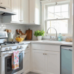 A small kitchen with light and neutral colors, including whites, soft greys, and pale blues, making the space feel open and airy. The design has a clean, timeless look with pops of color from accents like colorful dish towels, a vibrant backsplash, and a bold rug. The space is bright and inviting, with just the right amount of color to keep it lively and visually interesting.